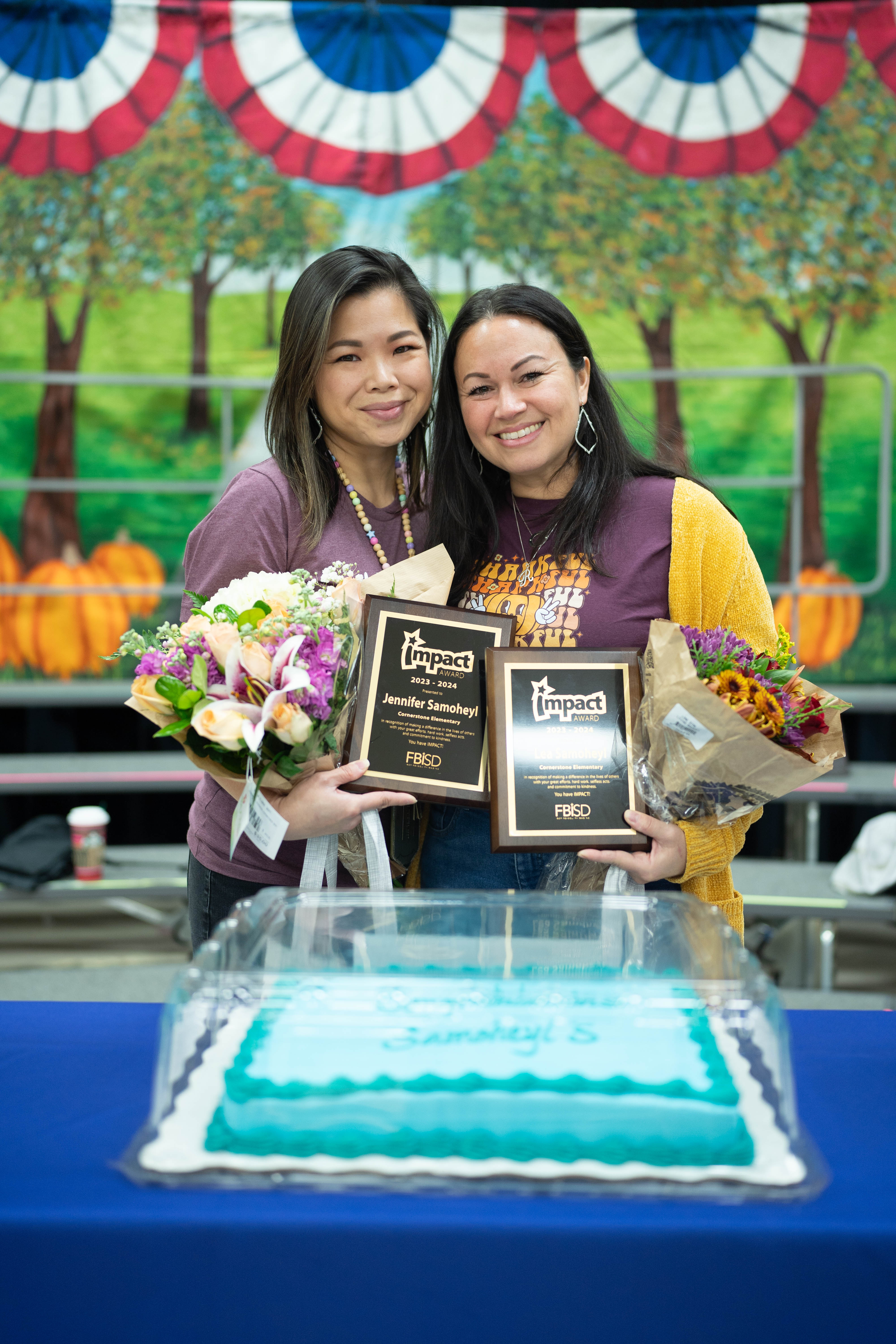 Jennifer and Lea Samoheyl holding their Impact Award plaque